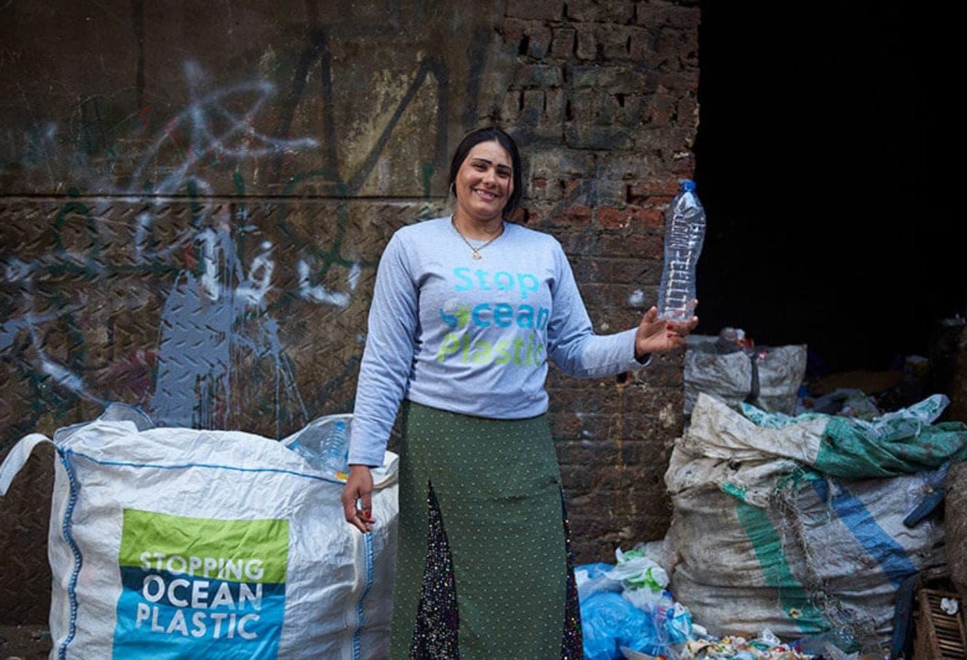A Plastic Bank member in Egypt beside sacks of collected plastic
